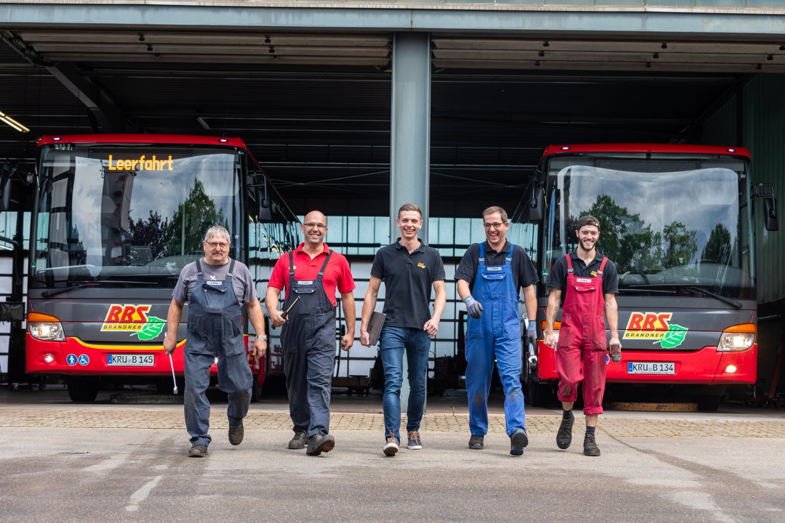 Team im Gespräch vor den Firmenbussen
