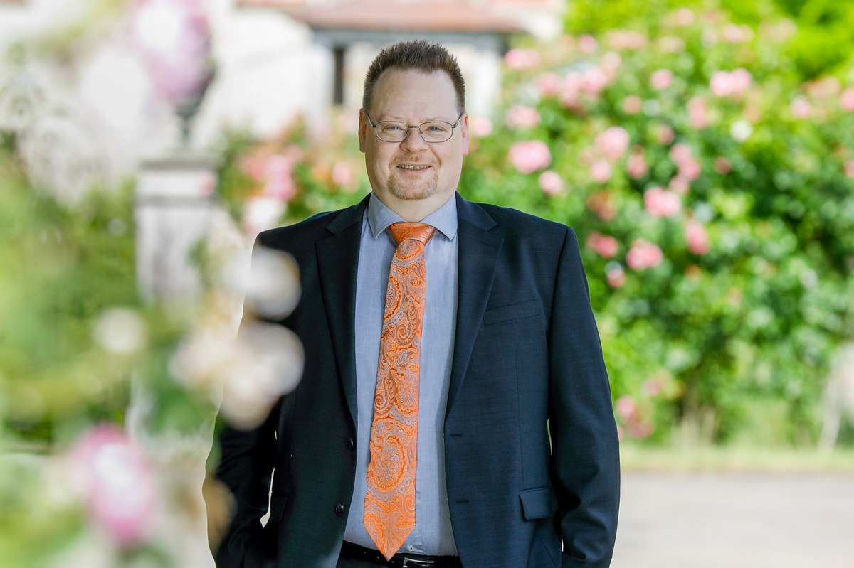 Business-Portrait im Grünen mit Krawatte, entspannte Pose