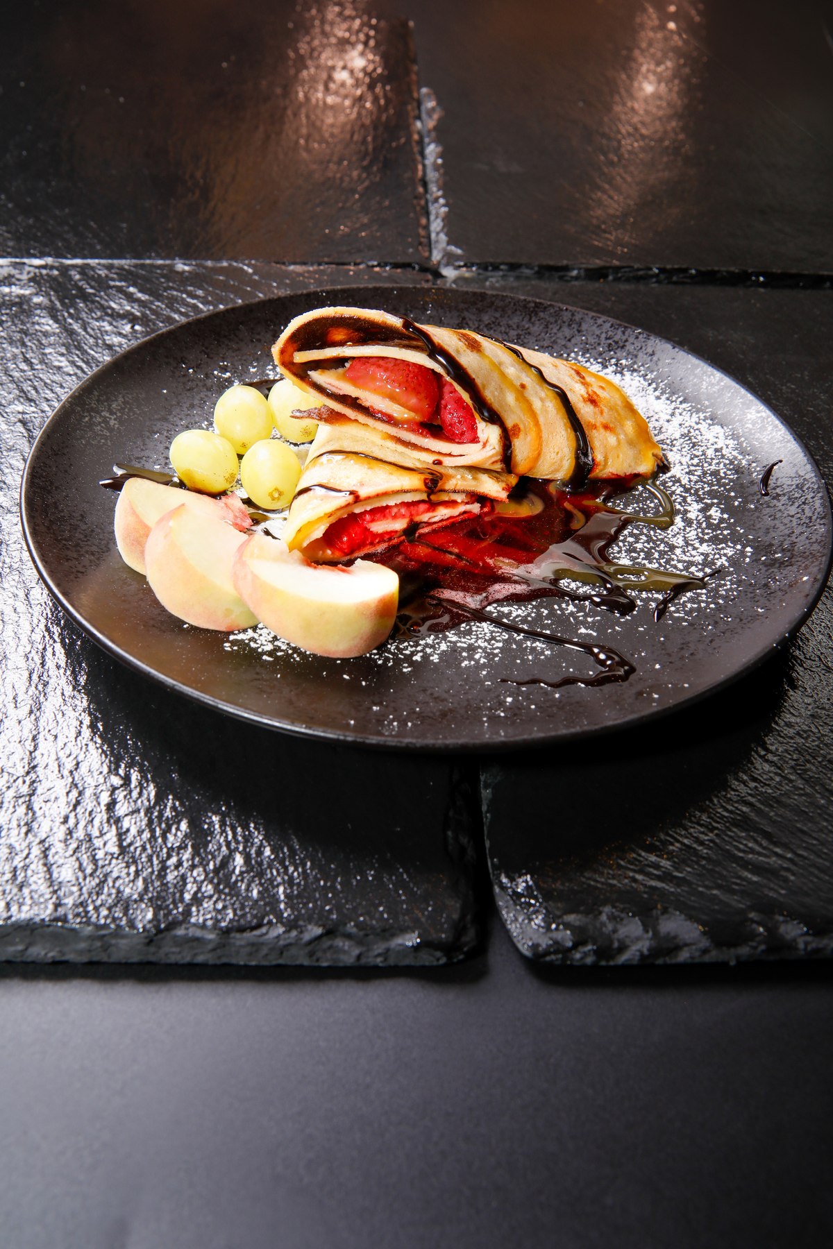 Dessert-Crêpe mit Erdbeeren, Schokoladensauce und frischem Obst