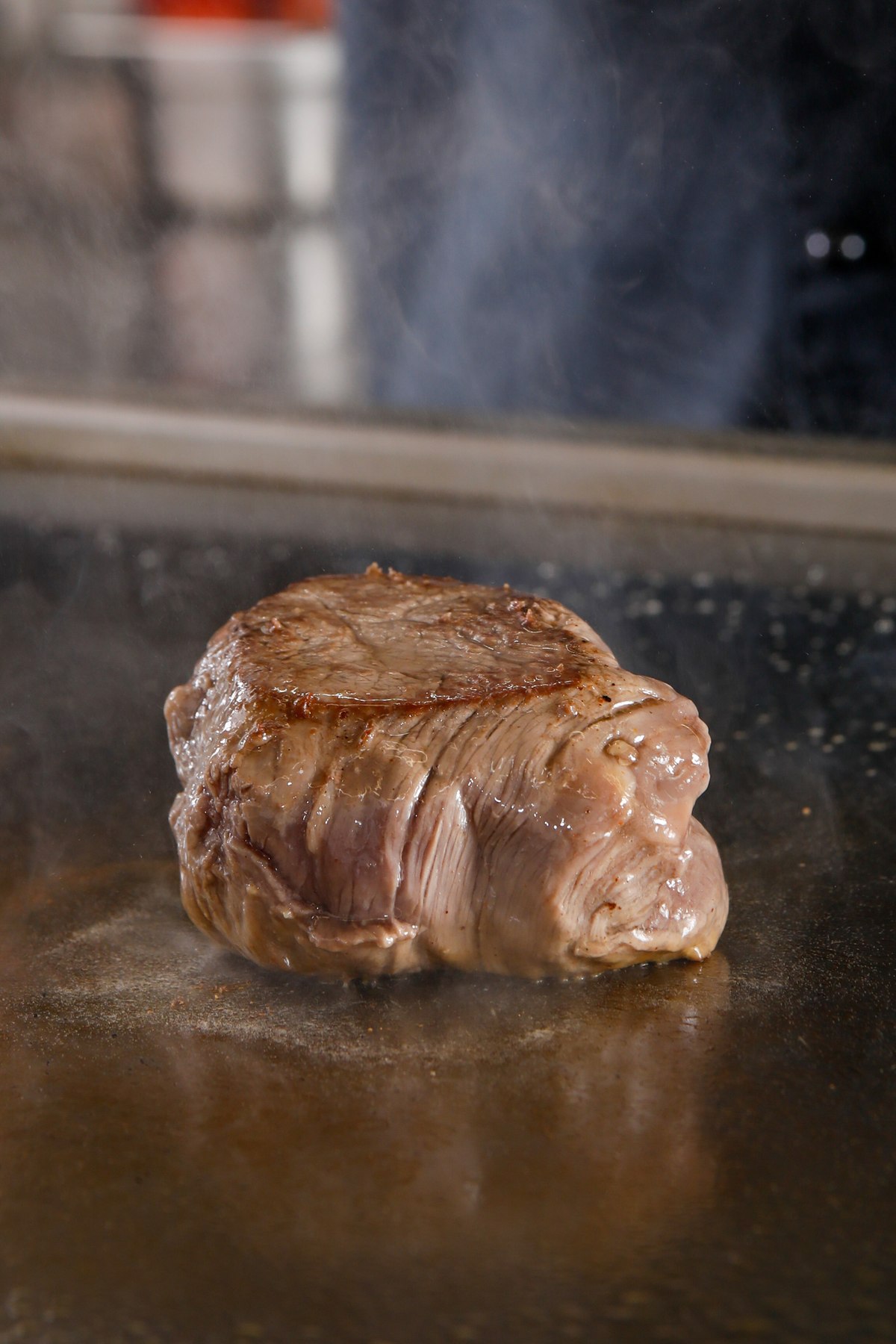 Angebratenes Steak auf heißer Grillplatte, Nahaufnahme mit Dampf