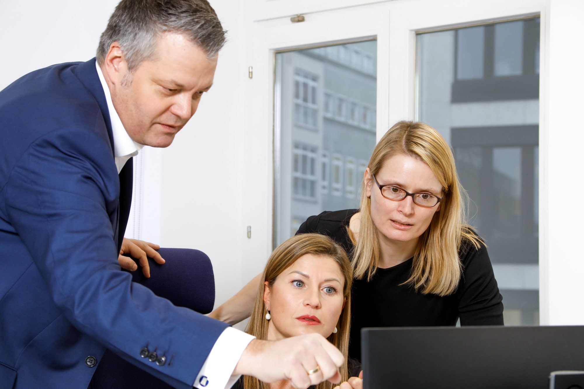 Team im Gespräch vor Kunstwand