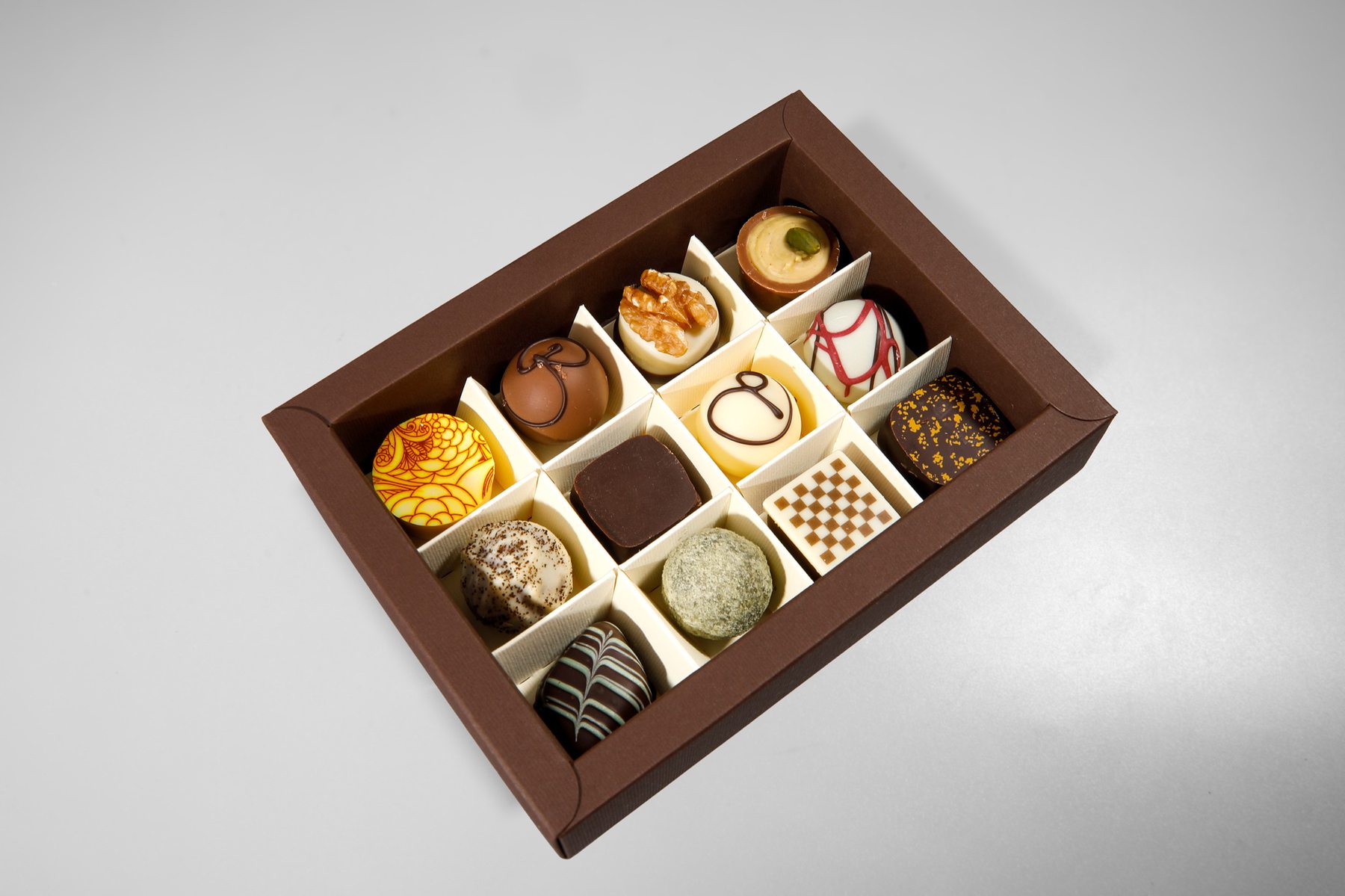 Offene Pralinenbox mit zwölf Pralinen