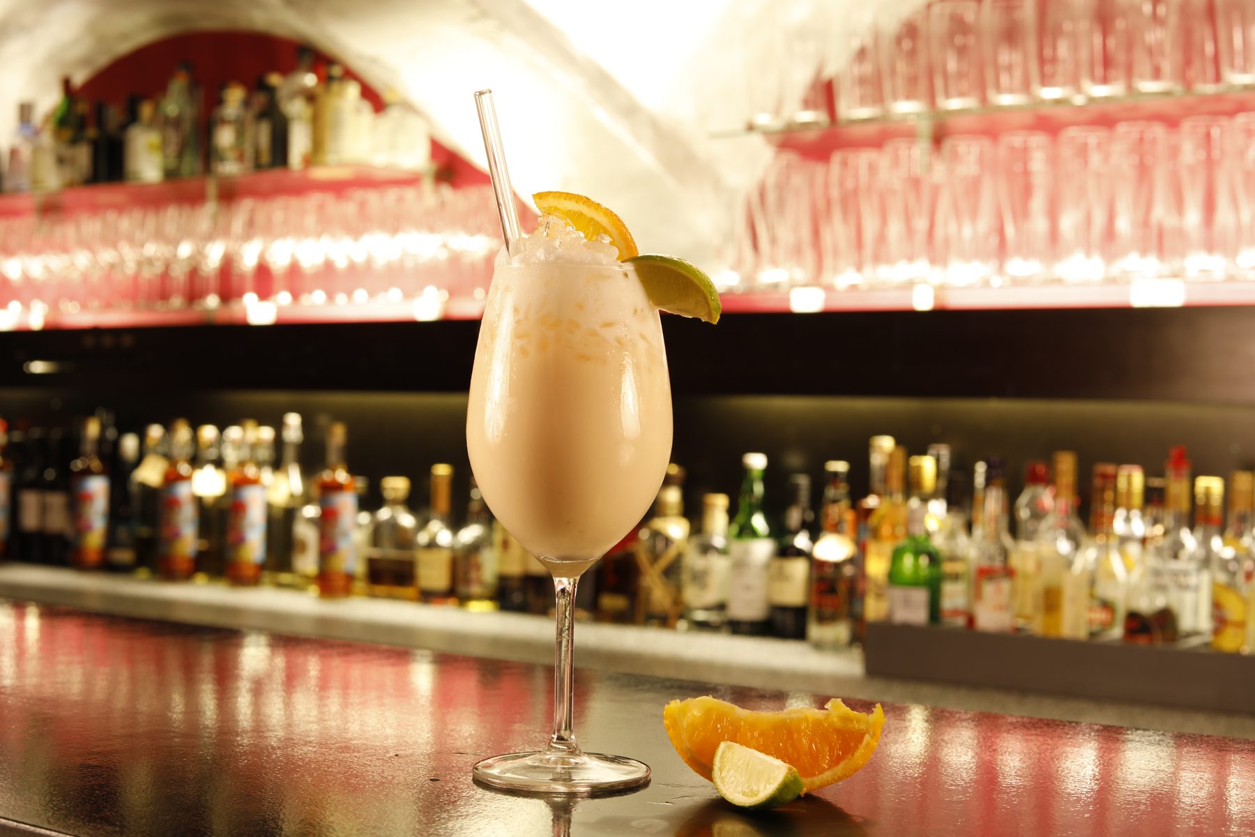 Cremiger Cocktail in Coupe-Glas mit Zitrusgarnitur