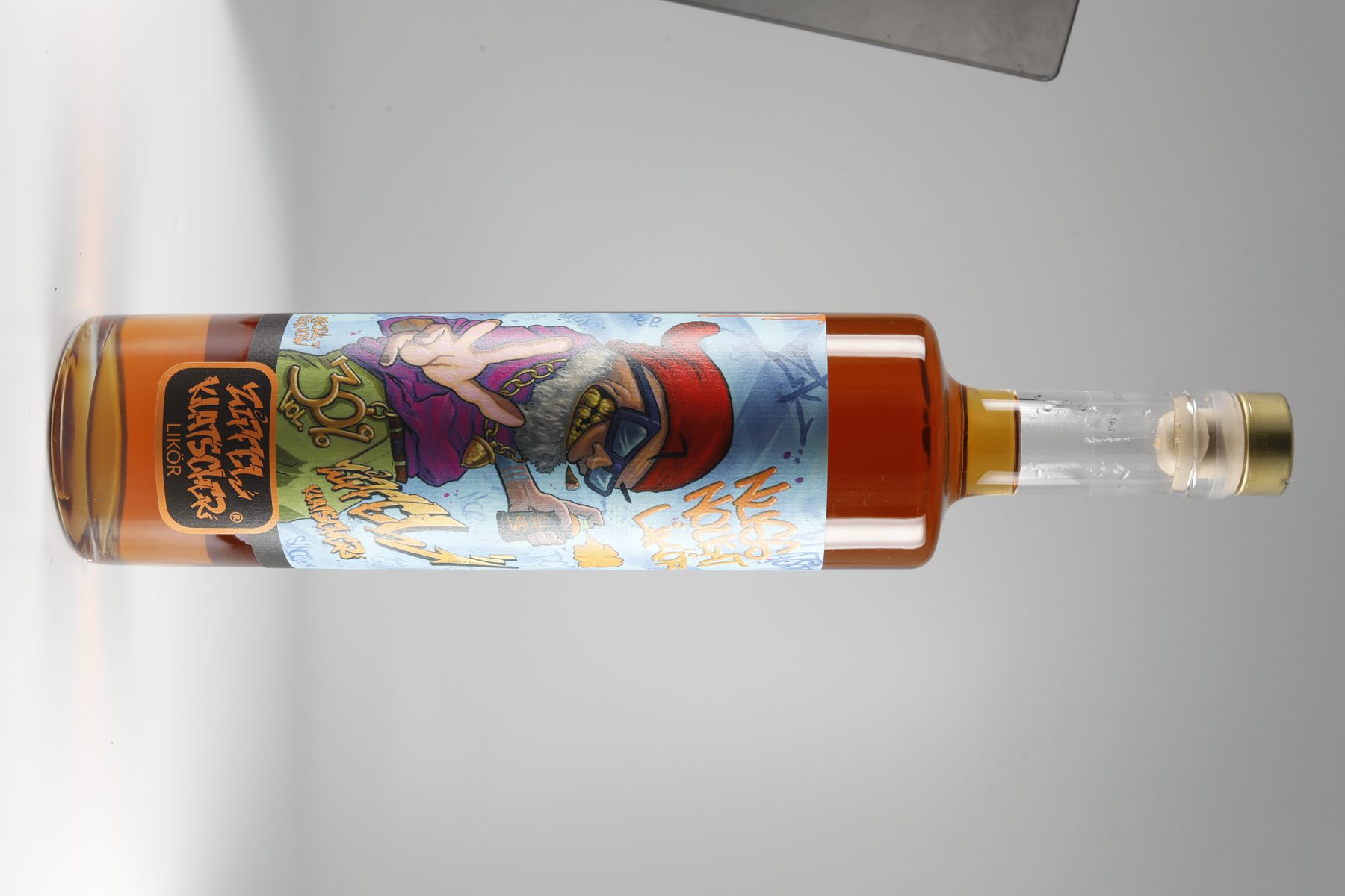 Spirituosenflasche diagonal vor hellgrauem Studiohintergrund