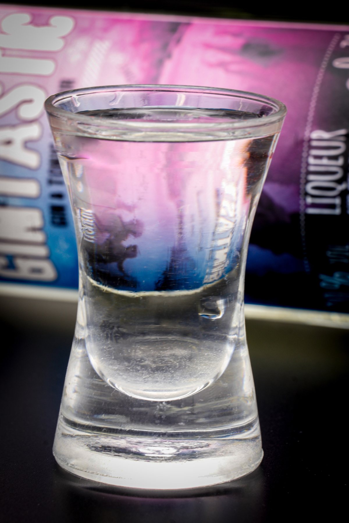 Shotglas mit Spiegelung des Flaschenetiketts, Bar-Ambiente