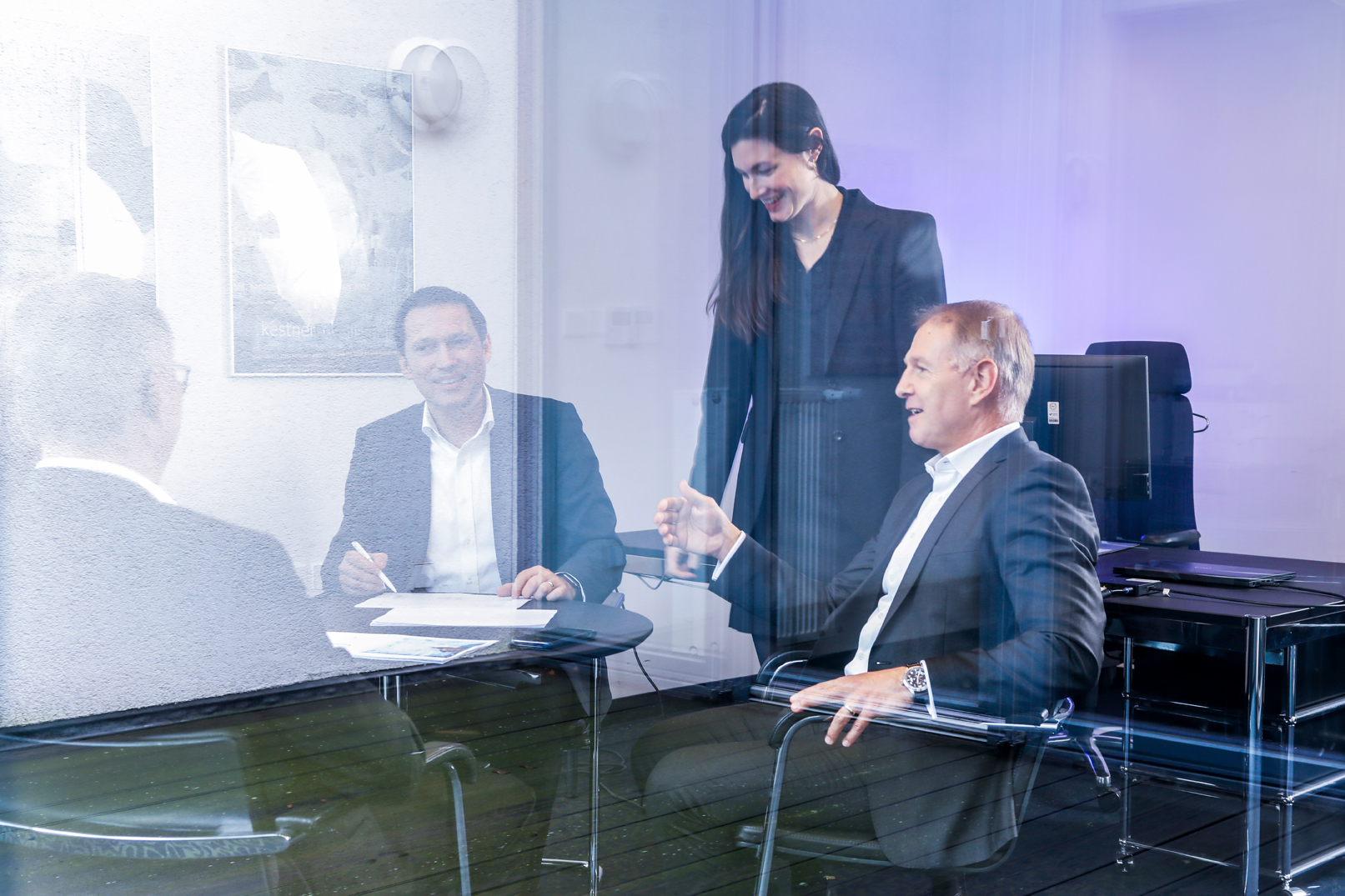 Team im Meetingraum mit violetter Spiegelung