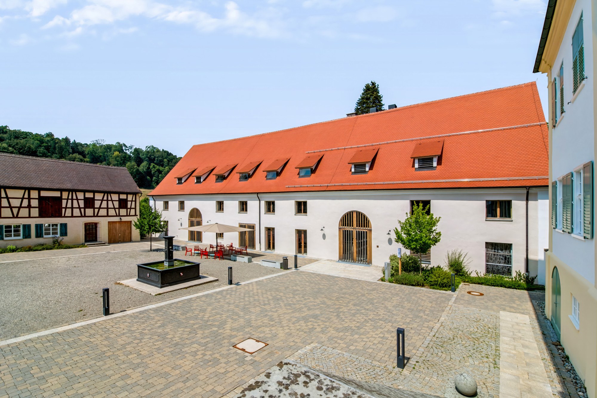 Umgebaute Zehntscheuer, Gebäudeansicht über den Hof mit Landschaftskulisse